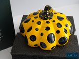 a yellow and black polka dot pumpkin with a bow on top