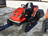 a small red tractor parked next to a smaller orange tractor