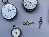 many different types of pocket watches on the table