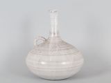 a white vase with a handle sitting on a table