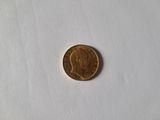a small coin on a white surface with a small piece of paper