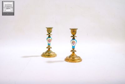 deux bougeoirs en or ornés de motifs bleus et roses