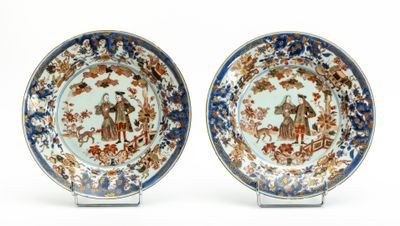 paire d'assiettes bleues et blanches ornées d'un motif représentant un homme et une femme dans un jardin