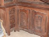 a corner cabinet with a mirror on top of it