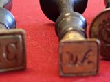 three metal stampers sitting next to each other on a red surface