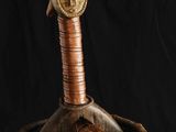 une photo représentant une sculpture en bois représentant une tête d'homme dans un panier en osier