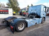 a blue semi truck parked in a lot with other semi trucks in the background