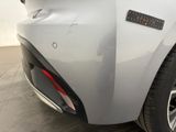 the rear end of a white car with a red brake light on