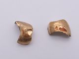 a pair of gold earrings on a white surface