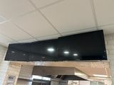 un grand téléviseur à écran plat fixé au plafond au-dessus d'une cuisinière