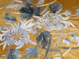 a close up of a floral design on a bed