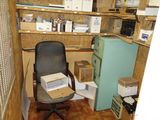une chaise qui se trouve dans une pièce où il y a des cartons sur les étagères