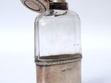 a small glass bottle with a metal stopper on top of it