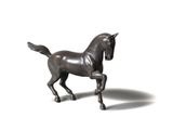 une statue représentant un cheval debout sur une surface blanche