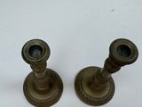 pair of antique brass candlesticks on a white background