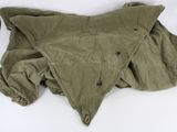 an image of a green jacket laying on top of a white surface