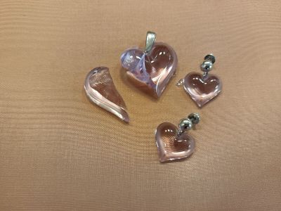 four pieces of heart shaped glass sitting on top of a table
