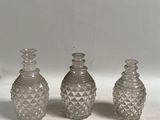trois vases en verre transparent posés sur un comptoir blanc