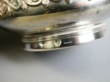 a silver bowl with a flower design on it