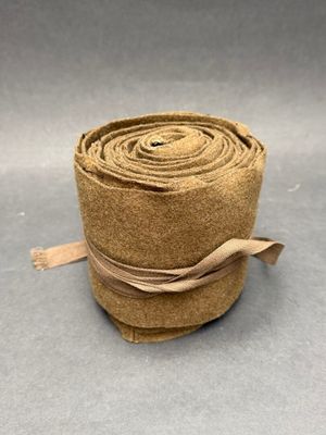 un gros plan sur un rouleau de tissu marron posé sur une surface grise