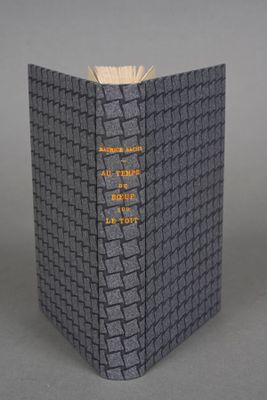 an open book sitting on top of a table next to a gray table