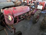 a red tractor that is parked in a garage