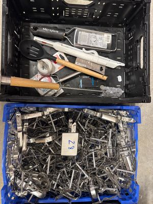 de nombreux outils dans une boîte en plastique posée par terre