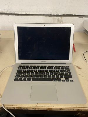 un ordinateur portable posé sur une table en bois