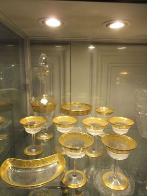 a glass display case with a lot of gold dishes