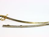 pair of gold plated swords with a curved blade on a white background