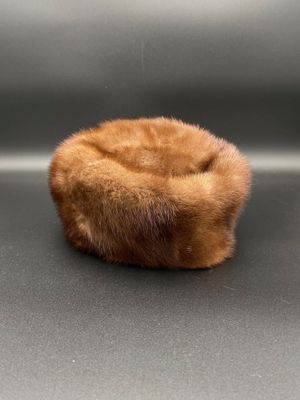 a brown fur hat sitting on top of a black surface