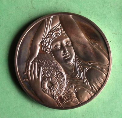 an image of a bronze medal with a woman holding a baby