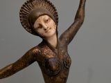 statue of a woman with a hat on her head and arms outstretched
