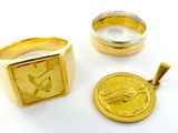 deux bagues en or et une pièce d'or sur un fond blanc
