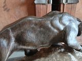 a statue of a bear on a rock in front of a door