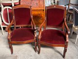 une paire de fauteuils recouverts de velours rouge, placés devant une commode