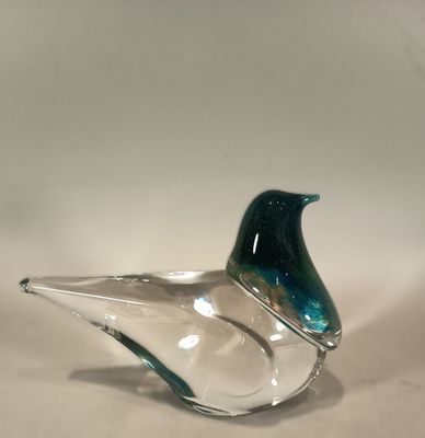 a glass bird sitting on top of a glass bowl