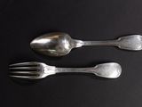 two spoons and a fork on a black surface