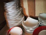 a stack of plates and cups on a table