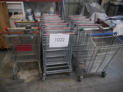 de nombreux chariots de supermarché dans un entrepôt, sur lesquels sont apposées des étiquettes de prix