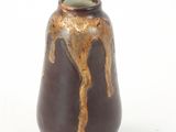 a brown vase that has a brown drip on it