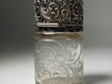 a glass jar with a silver lid sitting on a table