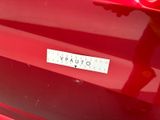a close up of a red car with a sticker on it