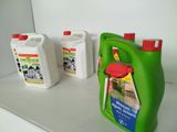 three bottles of liquid sitting on a shelf