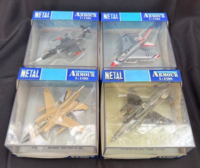 trois boîtes contenant des maquettes d'avions en métal, posées sur une surface noire