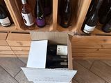 many bottles of wine sitting in a box on the floor