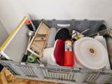a metal container filled with assorted items on top of a hard wood floor