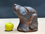 a statue of a dog and an apple on a table