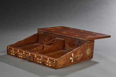 une vieille boîte en bois comportant un tiroir à l'intérieur, posée sur une surface grise