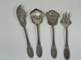 five silver spoons and a spoon with a flower design on them